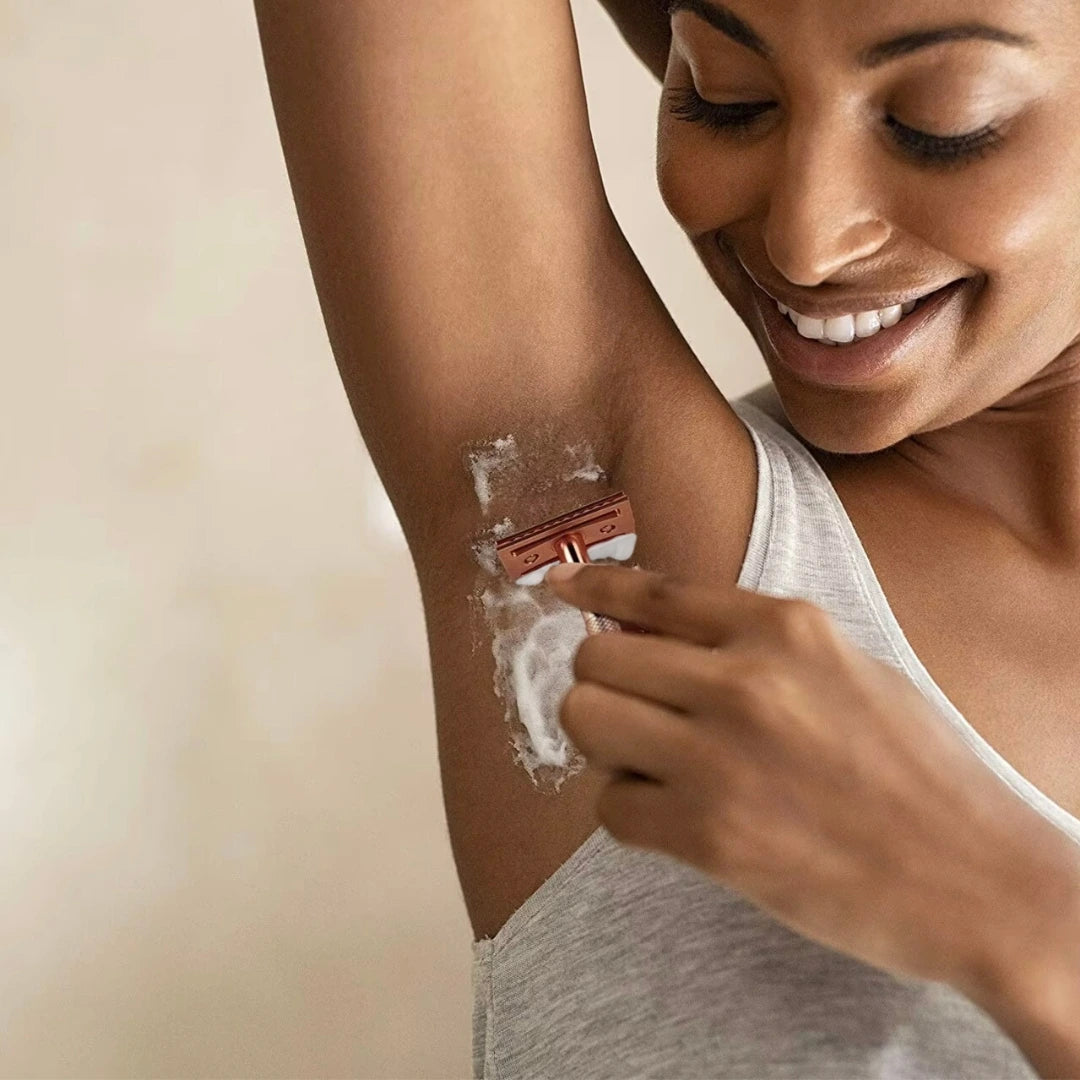 Woman shaving her arm with a razor, smiling.